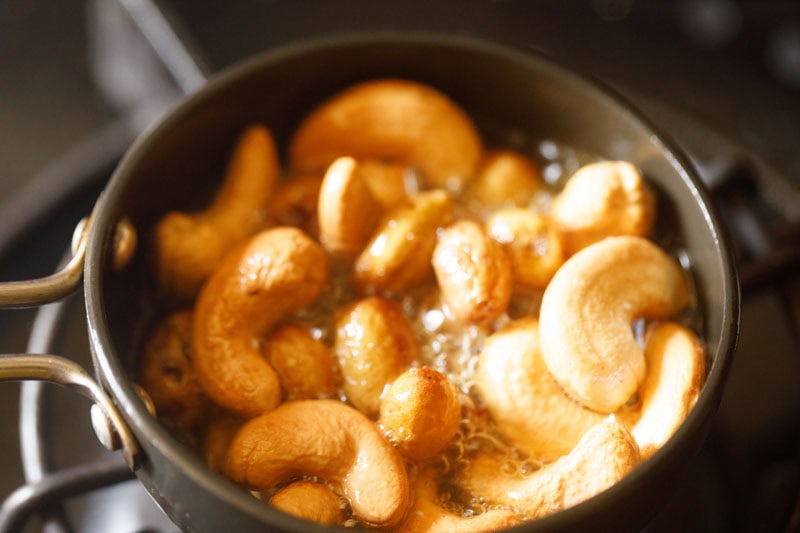 Cashews and raisins being fried in ghee.