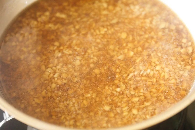 Jaggery syrup mixed with cooked ada in pan.