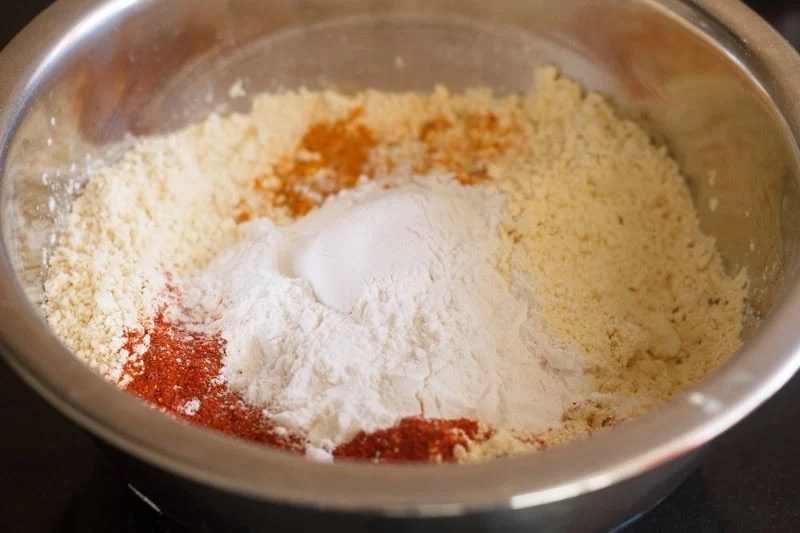 Rice flour and ground spices with gram flour in bowl.