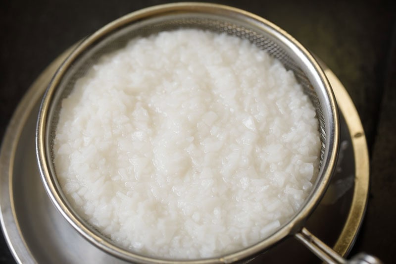 Straining cooked ada in a mesh strainer,