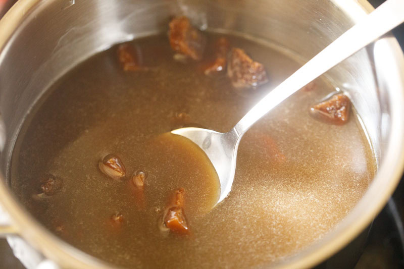 Jaggery being mixed with a spoon.