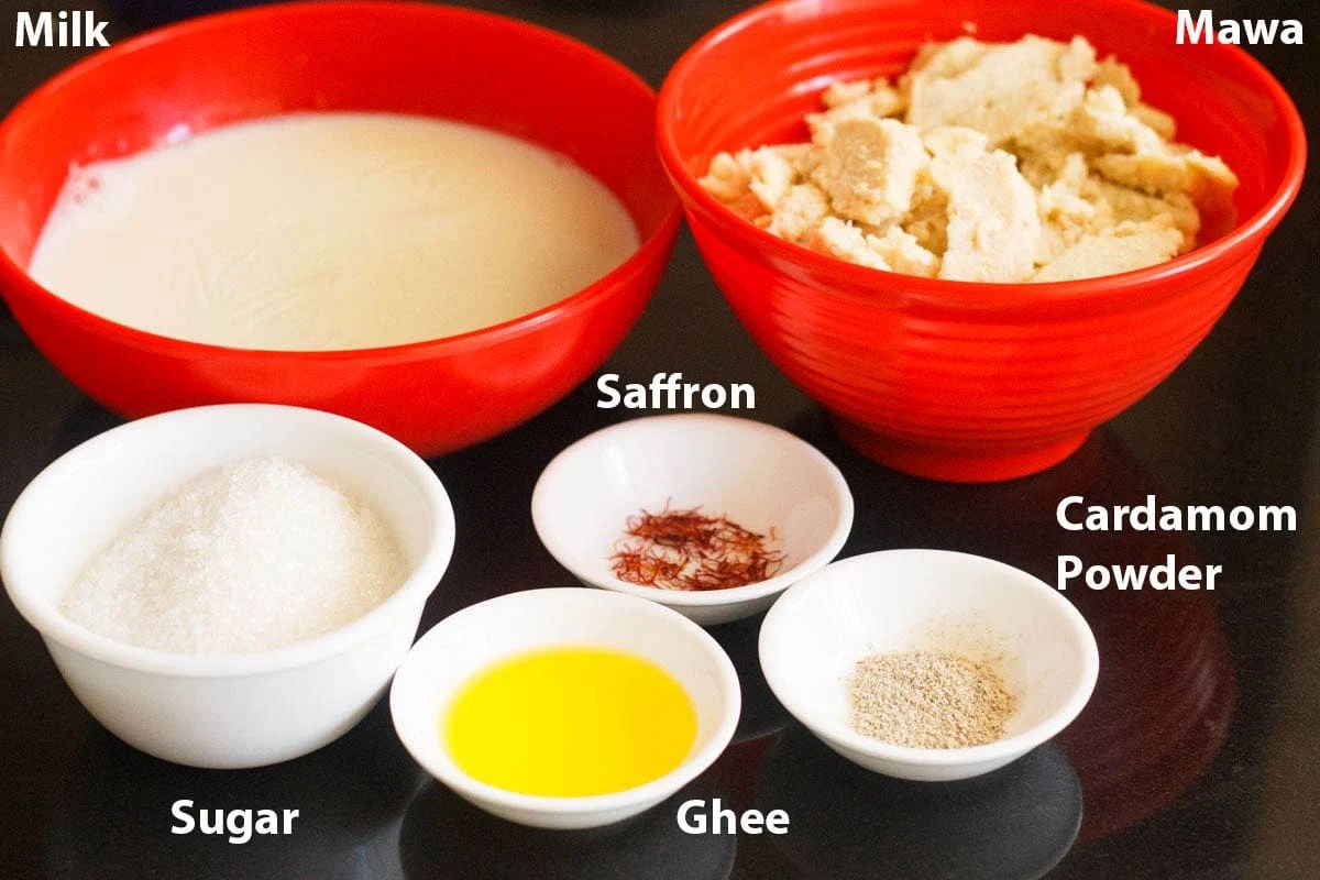 Ingredients for mawa peda kept in red and white bowls.