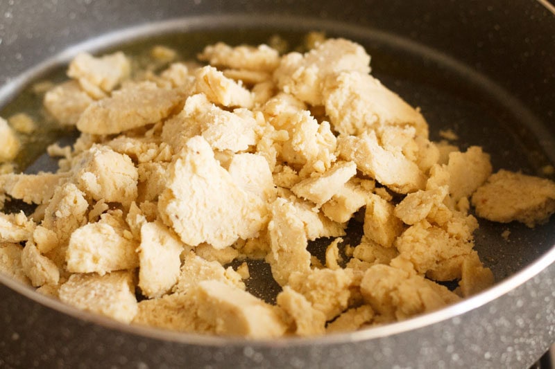 Crumbled mawa (khoya) in a thick bottomed pan.