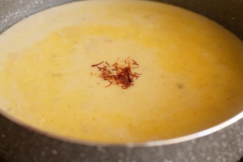 Crushed saffron strands over liquid mixture.