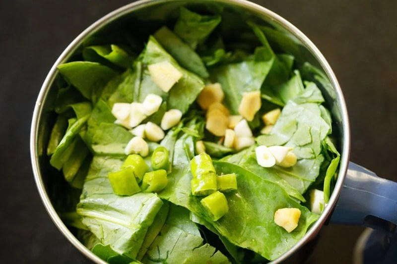Fresh spinach, ginger, green chilies and garlic in a blender.
