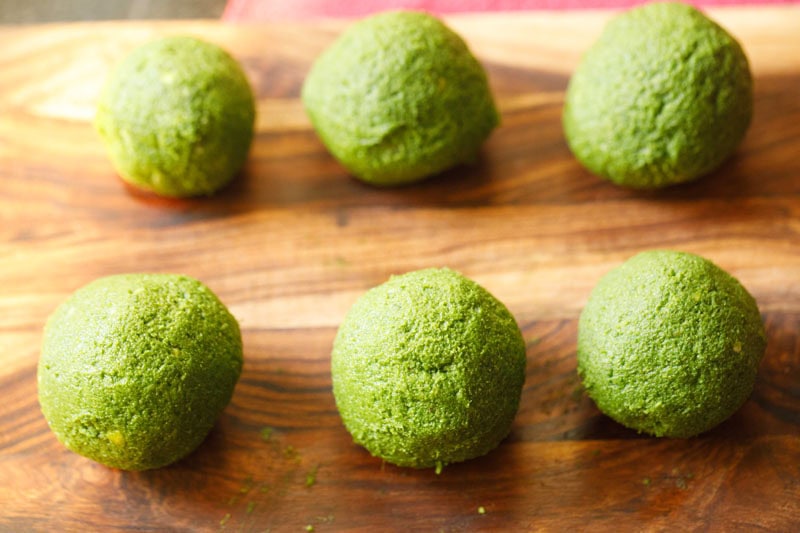 Palak kofta balls on wooden board.