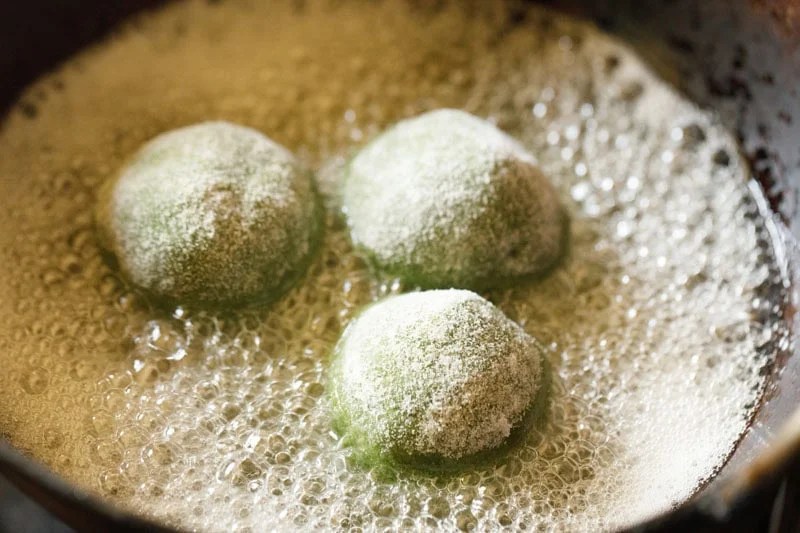 Palak koftas frying in oil.