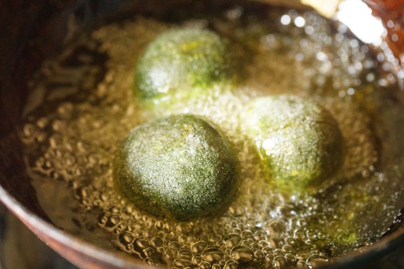 Palak koftas frying in oil.