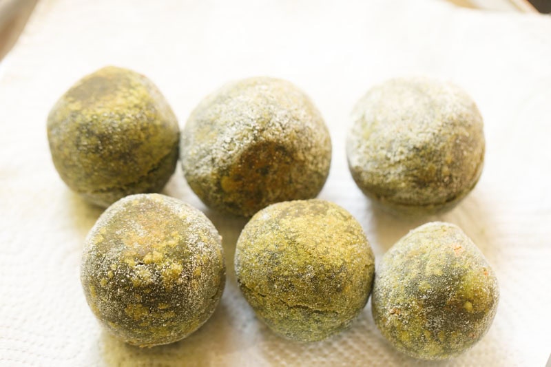 Fried spinach koftas on paper towels.
