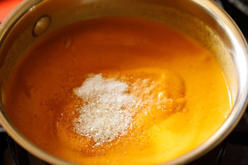 Salt and sugar sprinkled on orange gravy.